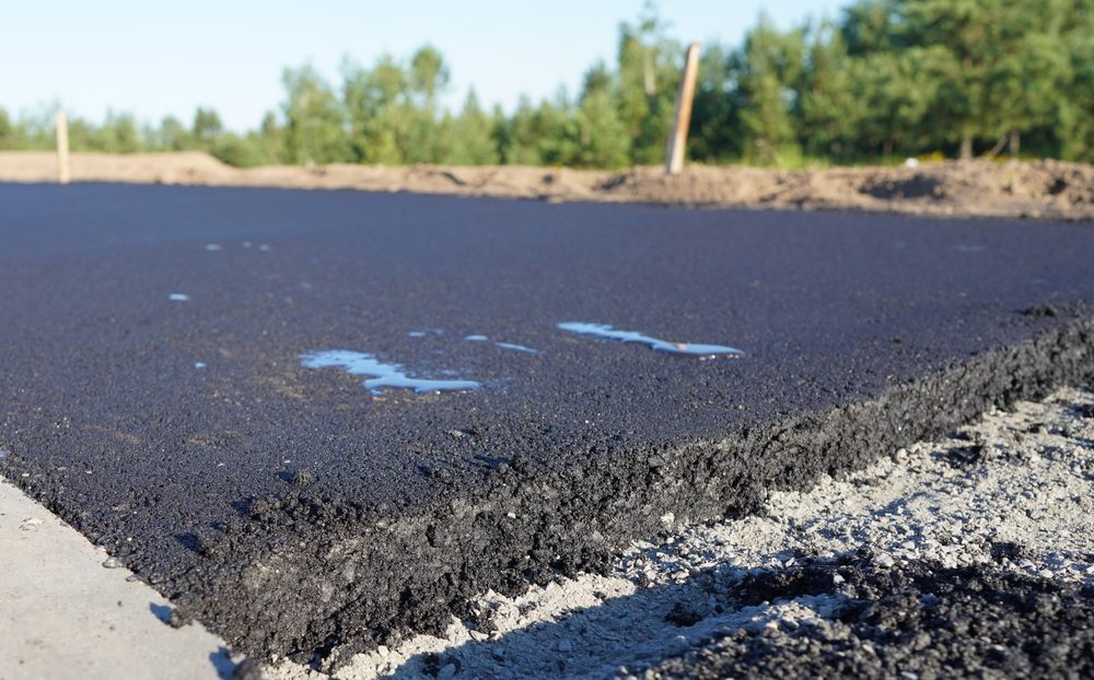 How to Choose the Right Asphalt Repair Service for Your Ottawa Home. Asphalt road after laying asphalt. New asphalt road renovation. Road construction. Paved sidewalk. Black tarmac pedestrian road, repair. Black tarmac rebuilding. Street Asphalting.