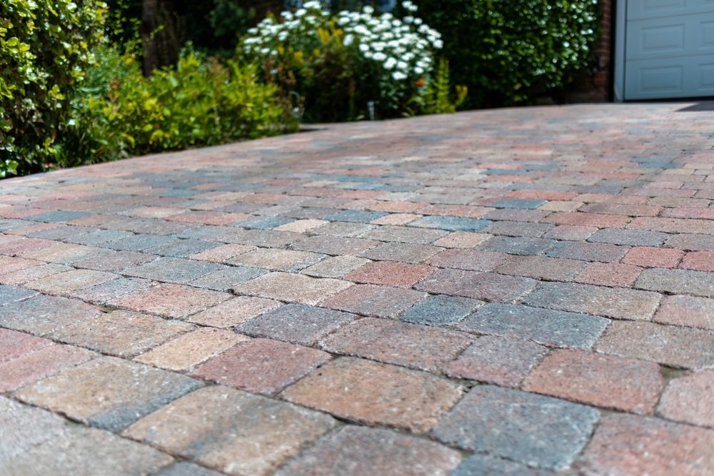 The Ultimate Guide to Interlocking Driveway Designs for Modern Homes. Coloured interlocking block paved driveway at an attractive suburban property.